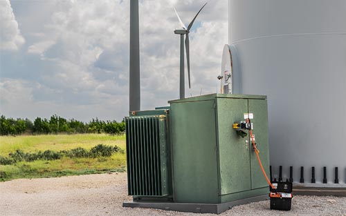 RSK-PMT remote switch kit for pad-mounted transformers, installed at a windfarm with a wind turbine behind it.